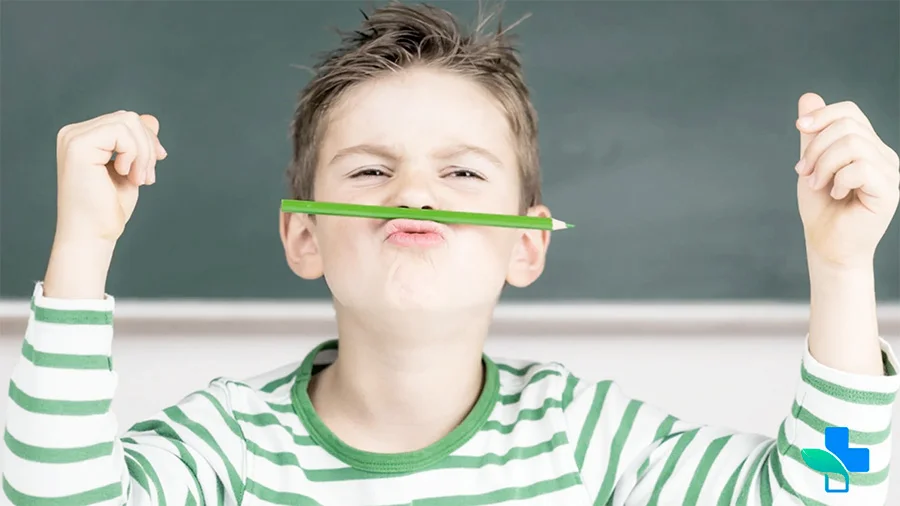 Мальчик держит карандаш у губ