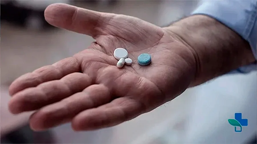 Мужчина держит таблетки на руке