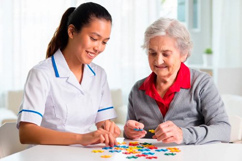 Врач сидит с пожилой женщиной