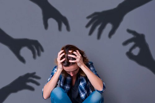 К девушке тянутся тени рук